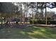 Community playground featuring play structures, swings, and a wood chip ground cover for safety at 10662 Woodchase Cir, Orlando, FL 32836
