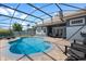 Enclosed pool with patio furniture, tanning chairs, and brick pavers at 10662 Woodchase Cir, Orlando, FL 32836