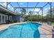 Relaxing pool area with chairs, dining set and screened-in enclosure at 10662 Woodchase Cir, Orlando, FL 32836