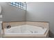 Soaking tub features tile surround, jets, and bright natural light at 10662 Woodchase Cir, Orlando, FL 32836