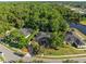 Aerial view showcasing a beautiful home surrounded by mature trees and a tranquil pond at 1125 E Tuskawilla Pt, Winter Springs, FL 32708