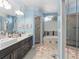 Primary bathroom with dual sink vanity, glass enclosed shower and soaking tub with window at 1125 E Tuskawilla Pt, Winter Springs, FL 32708