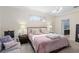Bright bedroom with a plush bed, ambient lamps, and direct access to the bathroom at 1125 E Tuskawilla Pt, Winter Springs, FL 32708