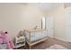 Bright and airy Bedroom with a crib, side table, and a pink flamingo, perfect for a new baby at 1125 E Tuskawilla Pt, Winter Springs, FL 32708