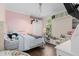 Bright bedroom featuring pink walls, wood floors, built-in shelving, and ample space for play and relaxation at 1125 E Tuskawilla Pt, Winter Springs, FL 32708
