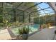 Beautiful screened pool with a stone waterfall feature surrounded by lush landscaping at 1125 E Tuskawilla Pt, Winter Springs, FL 32708