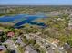 Expansive aerial shot of the community with a lake, mature trees, and various single Gathering homes at 1137 Palm Cove Dr, Orlando, FL 32835