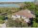 Aerial view of a single-Gathering home with a screened pool, lush landscaping, and a serene lake in the background at 1137 Palm Cove Dr, Orlando, FL 32835
