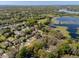 Panoramic aerial view of a residential neighborhood with a lake, tree-lined streets, and well-maintained homes at 1137 Palm Cove Dr, Orlando, FL 32835