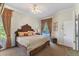 This primary bedroom features an ornate bed frame and view of the backyard pool at 1137 Palm Cove Dr, Orlando, FL 32835