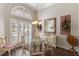 Elegant dining room with a glass table, a chandelier, large window and unique floral arrangements on the walls at 1137 Palm Cove Dr, Orlando, FL 32835