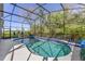 Screened-in pool area with a kidney-shaped pool, patio chairs, and lush greenery at 1137 Palm Cove Dr, Orlando, FL 32835