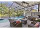 Screened-in pool area with a hot tub, comfortable seating, and a fire pit at 1137 Palm Cove Dr, Orlando, FL 32835