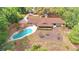 Aerial view of the backyard featuring a sparkling pool, wood fence, lush landscaping, and home with screened in lanai at 1212 Foxfire Dr, Apopka, FL 32712