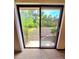 View of the backyard through sliding glass doors, showcasing landscaping and greenery at 1212 Foxfire Dr, Apopka, FL 32712