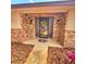 Close up of front door with wreath, brick facade, and exterior lantern sconces at 1212 Foxfire Dr, Apopka, FL 32712