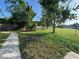 Fenced backyard with a spacious lawn and mature trees at 1221 Perkins Rd, Orlando, FL 32809