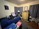 Bedroom with blue bedspread, dresser, and window with curtains at 1221 Perkins Rd, Orlando, FL 32809
