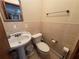 Cozy powder room features a pedestal sink and decorative wall tiles at 1221 Perkins Rd, Orlando, FL 32809