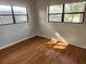 A bedroom with laminate flooring and two windows offering natural light at 132 Terrace Dr, Winter Haven, FL 33884