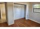 A bedroom with laminate floors, an empty closet, and a doorway leading to another room at 132 Terrace Dr, Winter Haven, FL 33884