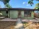 A single-story home with a wood-framed glass door and a small patio at 132 Terrace Dr, Winter Haven, FL 33884