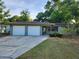 Charming single-story home featuring a two-car garage and lush green landscaping at 132 Terrace Dr, Winter Haven, FL 33884
