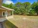 Picturesque backyard with mature trees, lush lawn and covered patio at 1406 Cr 542G, Bushnell, FL 33513
