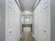 Hallway view of bright bathroom featuring white cabinets and an arched window overlooking a large bathtub at 1406 Cr 542G, Bushnell, FL 33513