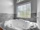 A luxurious soaking tub with jets sits below a large half-moon window at 1406 Cr 542G, Bushnell, FL 33513