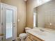 Neutral bathroom featuring a white single sink vanity, toilet, and a door to the outside at 1406 Cr 542G, Bushnell, FL 33513