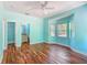 Spacious bedroom featuring blue walls, hardwood floors, windows and an open bathroom entrance at 1406 Cr 542G, Bushnell, FL 33513