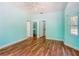 Bright bedroom with blue walls, hardwood floors, and doors leading to other rooms at 1406 Cr 542G, Bushnell, FL 33513