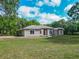 Sprawling single story home featuring a symmetrical facade and a large front lawn at 1406 Cr 542G, Bushnell, FL 33513