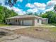 A tan stucco single-story home featuring a circular drive and a spacious two-car garage at 1406 Cr 542G, Bushnell, FL 33513