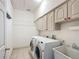 Bright laundry room with washer, dryer, sink, cabinets, and rod for hanging at 1406 Cr 542G, Bushnell, FL 33513