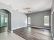 An open floor plan is showcased by a living room featuring wood-look floors, two windows and overhead lighting at 1406 Cr 542G, Bushnell, FL 33513