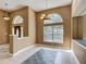 Open-concept living room with large windows and arched doorway featuring natural light at 1406 Cr 542G, Bushnell, FL 33513