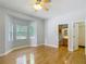 Spacious main bedroom featuring hardwood floors, a ceiling fan, and ample natural light from bay windows at 1406 Cr 542G, Bushnell, FL 33513