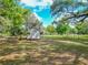 Expansive, tree-lined yard features a storage shed and is ideal for outdoor activities at 1406 Cr 542G, Bushnell, FL 33513