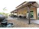 Back patio area with a shady covering, landscaping and comfortable seating at 15714 Turkey Farm Rd, Minneola, FL 34715