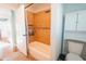 Bathroom with tile lined bathtub and shower featuring a built in storage cabinet at 15714 Turkey Farm Rd, Minneola, FL 34715