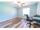 Bright bedroom featuring wood-look flooring, modern ceiling fan and a sunlit window at 15714 Turkey Farm Rd, Minneola, FL 34715