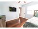 Bedroom featuring wood floors, ceiling fan, tv, and access to another room at 15714 Turkey Farm Rd, Minneola, FL 34715