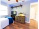 A cozy bedroom with wood floors, a ceiling fan, a reptile terrarium and access to another room at 15714 Turkey Farm Rd, Minneola, FL 34715