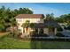 Charming two-story home with a well-manicured lawn and tropical landscaping, creating a welcoming curb appeal at 15714 Turkey Farm Rd, Minneola, FL 34715