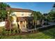 Inviting home featuring a manicured lawn, lush landscaping, and a charming covered entryway at 15714 Turkey Farm Rd, Minneola, FL 34715