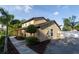 Two story home with tan stucco exterior, well-maintained landscaping and mature trees at 15714 Turkey Farm Rd, Minneola, FL 34715