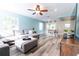Open-concept living room with modern flooring, plush seating, and plenty of natural light for a comfortable and inviting space at 15714 Turkey Farm Rd, Minneola, FL 34715