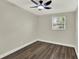 Bedroom features wood-look flooring, neutral paint, a ceiling fan, base molding, and a window with blinds at 1805 Knox Ave, Sanford, FL 32771